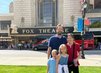 a mom and dad with their son and daughter, posing in front of the Fabulous Fox Theatre in St. Louis