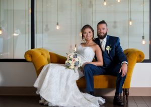 marriage photo of a bride on a couch next to her partner