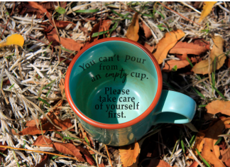 a coffee mug in the grass with the words, "you can't pour from an empty cup. Take care of yourself first."