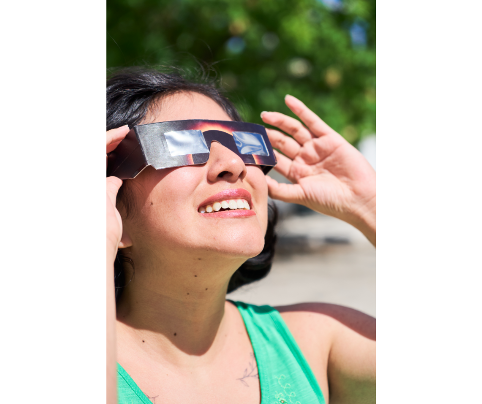 a woman gazing at the sun with eclipse glasses on