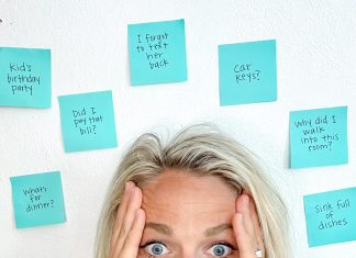 a mom with her eyes wide, hands up on the side of her face as she is surrounded by post it notes symbolizing ADHD as a mom