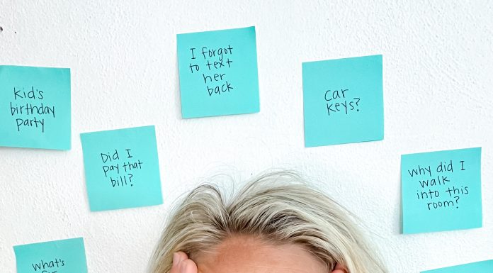 a mom with her eyes wide, hands up on the side of her face as she is surrounded by post it notes symbolizing ADHD as a mom