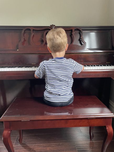 a boy sitting at the piano during music lessons