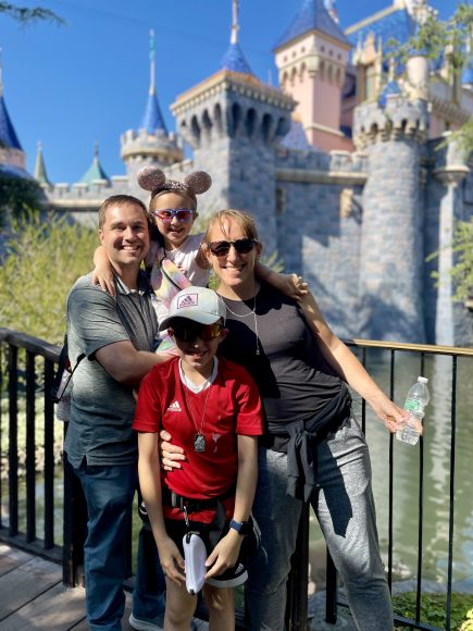 a family posing for a picture in front of Cinderella's castle at Disney World