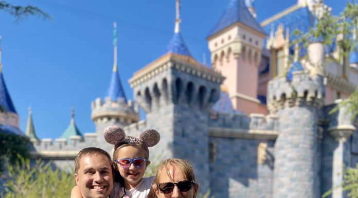 a family posing for a picture in front of Cinderella's castle at Disney World