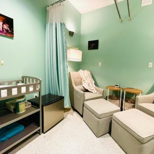 an example of lactation spaces as a small room with a changing table and glider is pictured