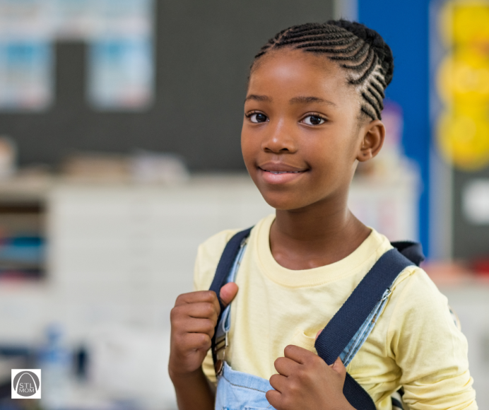 an African-American girl wearing a backpack at school