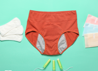 a pair of period underwear on a sea green background with tampons and pads next to it