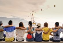 a photo of a group of friends sitting in a row, arms around each other's shoulders symbolizing diversity