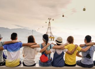 a photo of a group of friends sitting in a row, arms around each other's shoulders symbolizing diversity