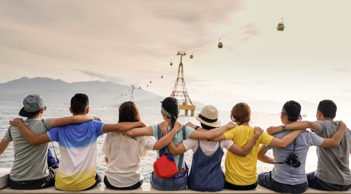 a photo of a group of friends sitting in a row, arms around each other's shoulders symbolizing diversity