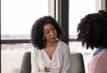 an African American psychiatric provider taking notes with a patient