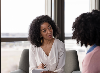 an African American psychiatric provider taking notes with a patient