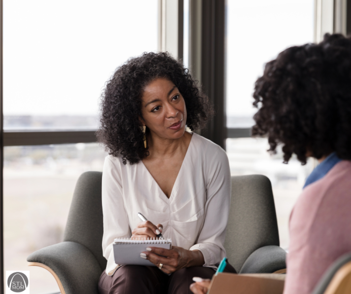 an African American psychiatric provider taking notes with a patient