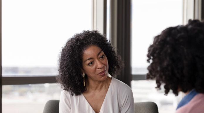 an African American psychiatric provider taking notes with a patient