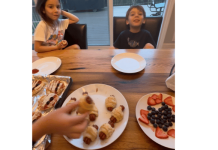 a plate full of Halloween treats sitting in front of two kids at the counter