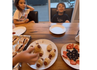 a plate full of Halloween treats sitting in front of two kids at the counter