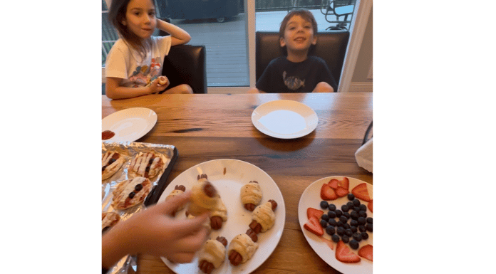 a plate full of Halloween treats sitting in front of two kids at the counter