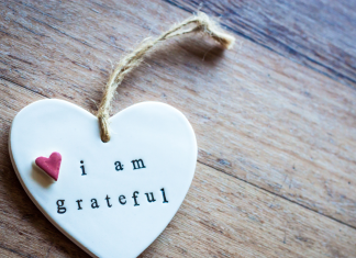 a white ceramic heart with the words, "I am grateful". There is a small red heart near the phrase