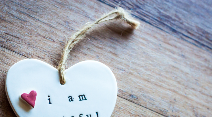 a white ceramic heart with the words, "I am grateful". There is a small red heart near the phrase