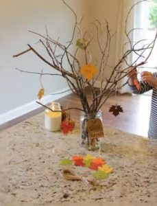 a vase with branches and paper leaves