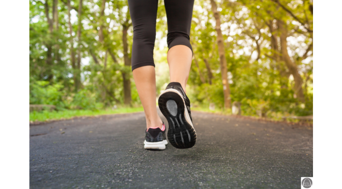 a close up of a woman's legs and feet as she takes a walk down a tree lined road