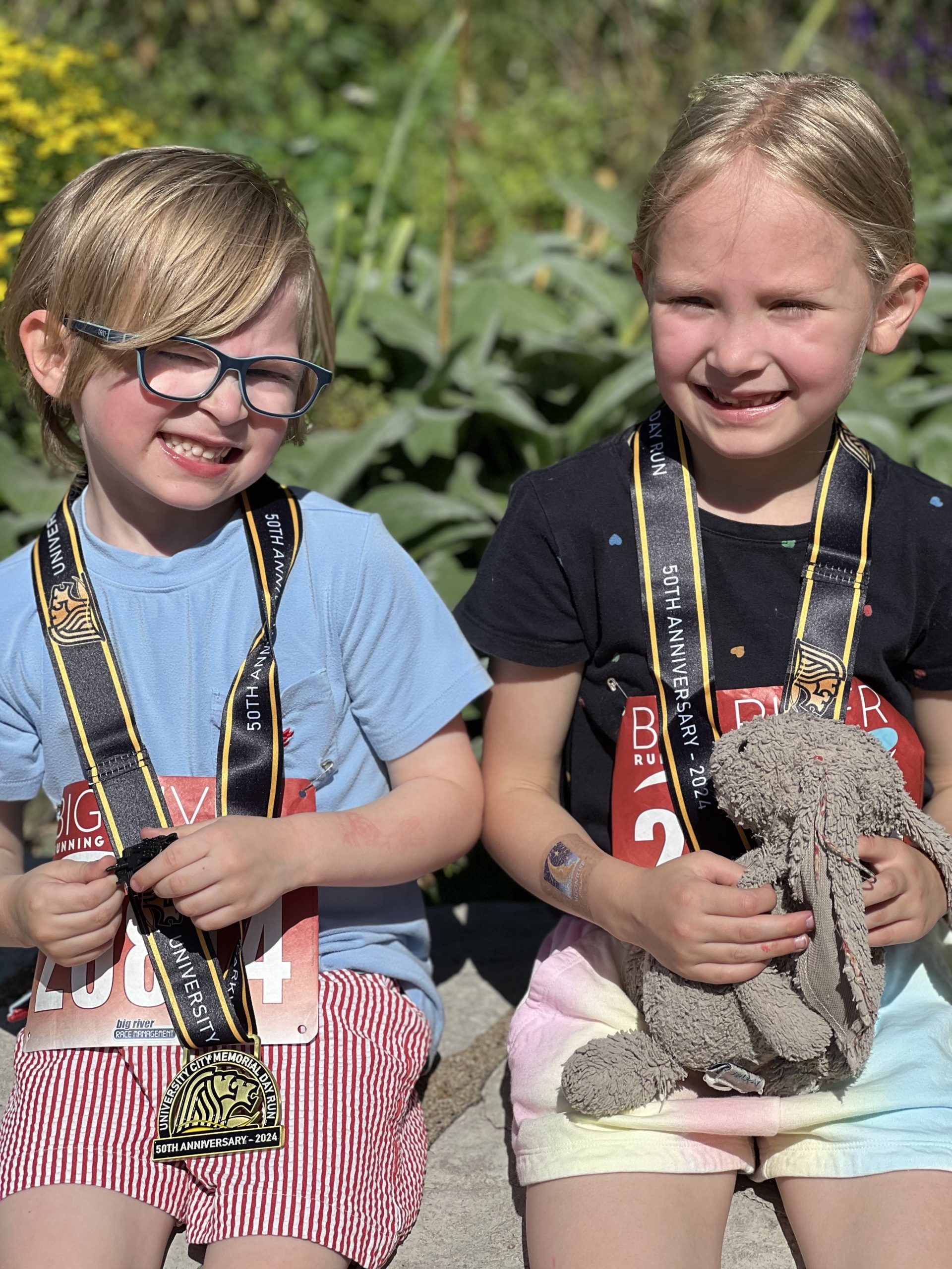 IMG_4357 a boy and a girl proudly wearing the medals they won running in a race
