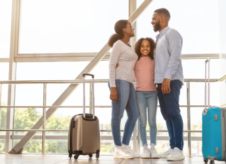 Family-Friendly Resorts with Non-Stop Flights from St. Louis an African American family in an airport with suitcases, ready to travel
