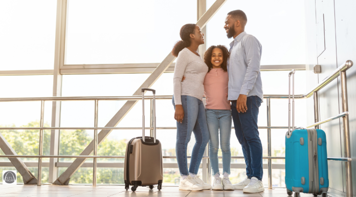 an African American family in an airport with suitcases, ready to travel