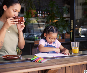 a mom fostering connection with her daughter as they sit together at a coffee shop