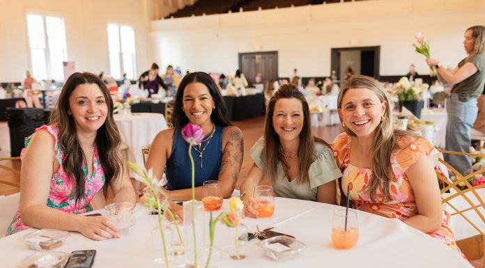 four moms sitting at a table at St. Louis Mom's Flourish 2025 event for motherhood