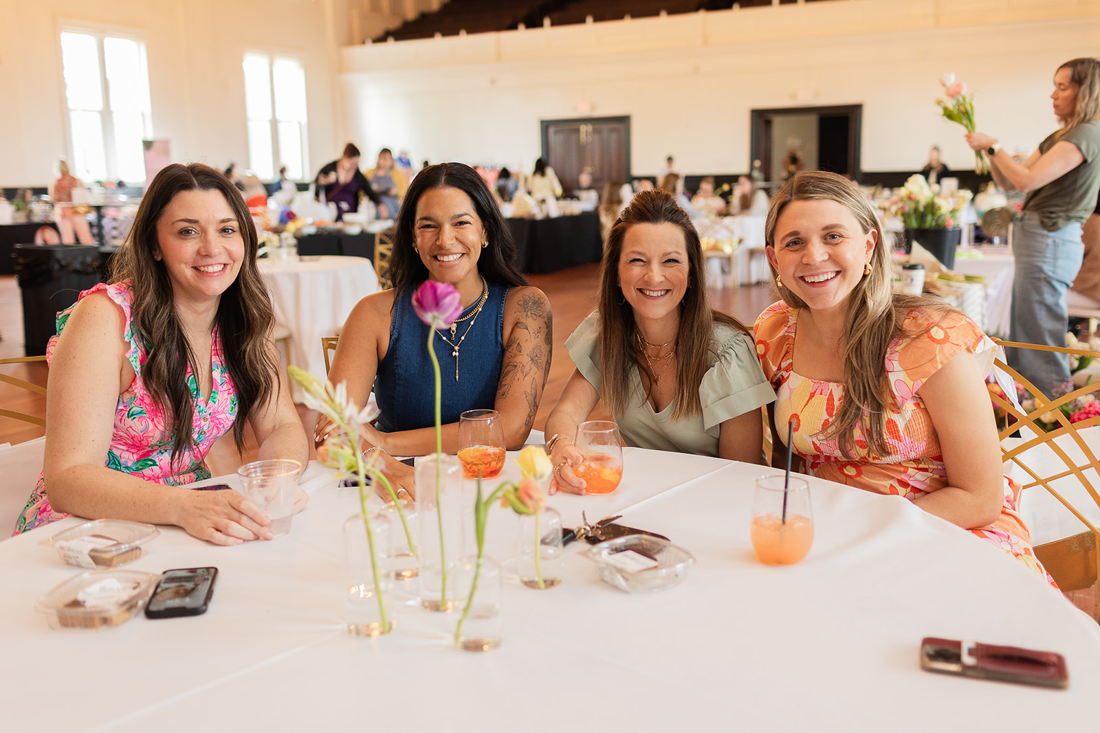 four moms sitting at a table at St. Louis Mom's Flourish 2025 event for motherhood