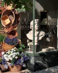 a statue and baskets artfully displayed in a window of a mom-owned small business