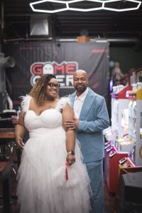 a man in a light blue suit and a woman in a white dress standing side by side for a photo at their vow renewal celebration