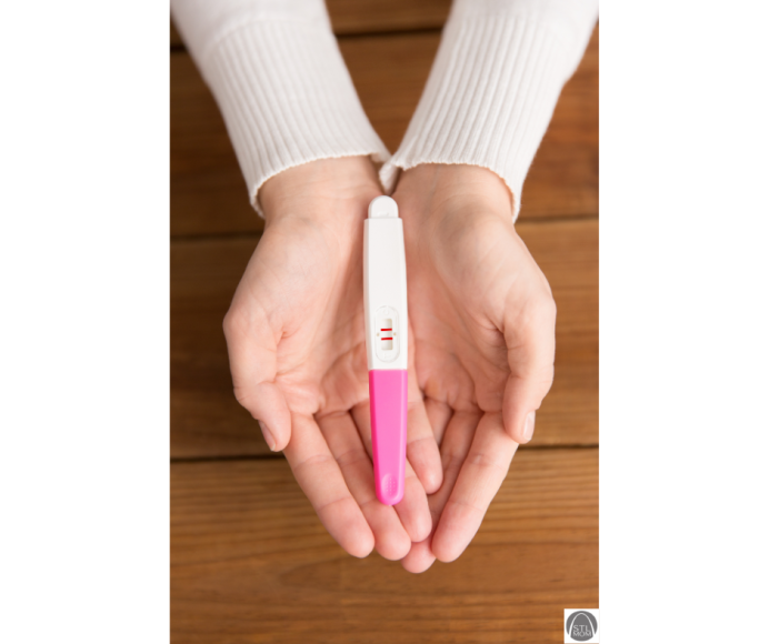 a positive pregnancy test sitting in the open hands of a woman