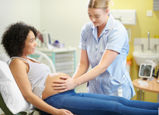 Preparing for Baby: Mom Edition a midwife with her hands on a pregnant woman's belly