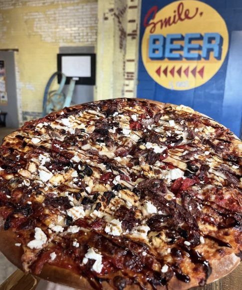 This Old Bakery Pizza is topped with honey bbq sauce, brisket, bacon, mozzarella, jalapeño and crispy onions.