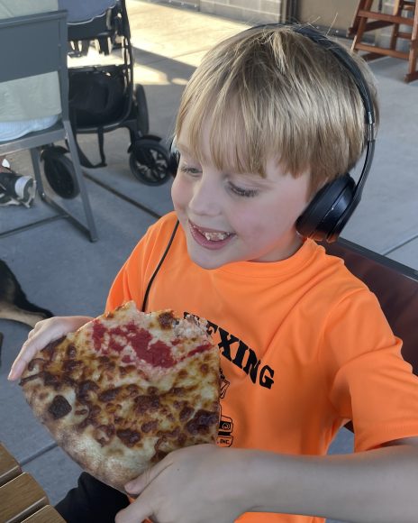 Our kiddo enjoying a slice of Side Project Pizza. The fries are also very popular with him.