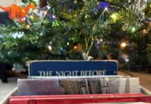 Making a Book List and Checking it Twice A candy-cane striped box of books under a Christmas tree.