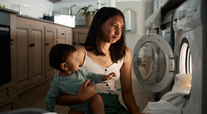 The Year I Stopped Living on Autopilot (And How You Can, Too) mom burnout autopilot Home, tired and mother with baby for laundry, household chores and parenthood with machine. House, child and mom with burnout expression to wash clothes, responsibility or electric appliance at night.