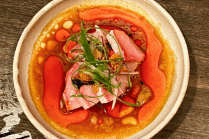 zoom in of isaan himachi from sado, blow with sauce and oil and fresh fish and herbs